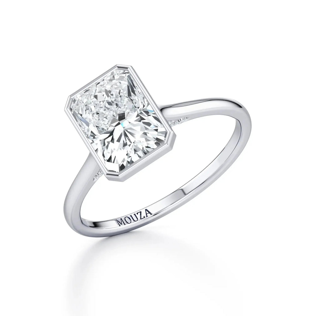 Radiant 18K white gold bezel set diamond engagement ring, labeled 'MOUZA' on the band.