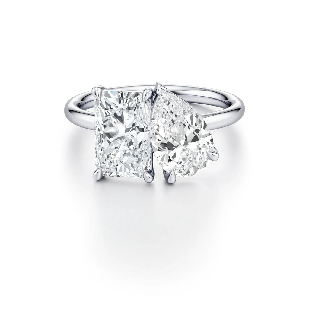 A platinum engagement ring with a classic floating band design, featuring two cushion-cut diamond center stones.