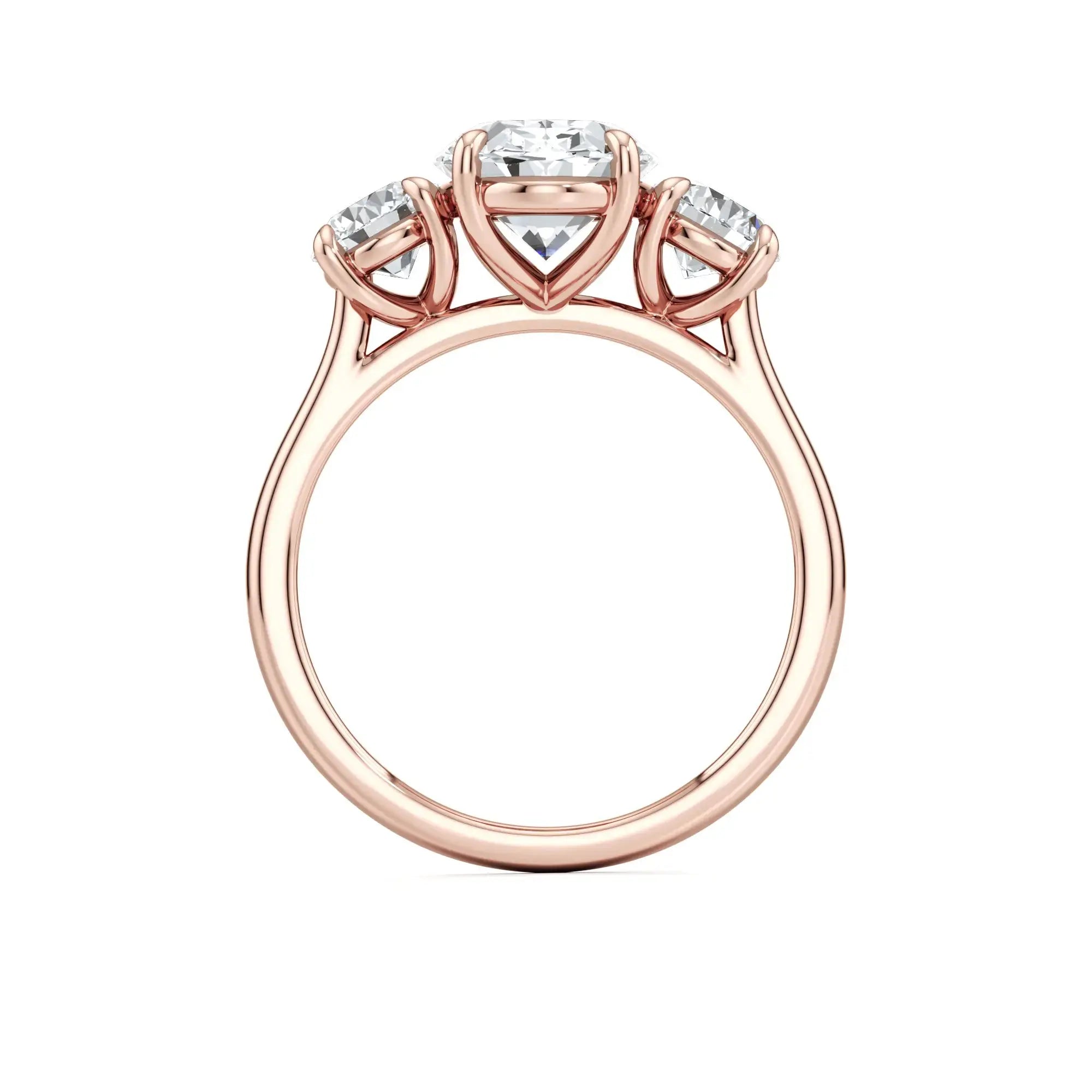 A classic three-stone engagement ring with round side stones and a central oval diamond, with a rose gold band having the brand name 'Mouza' on it.