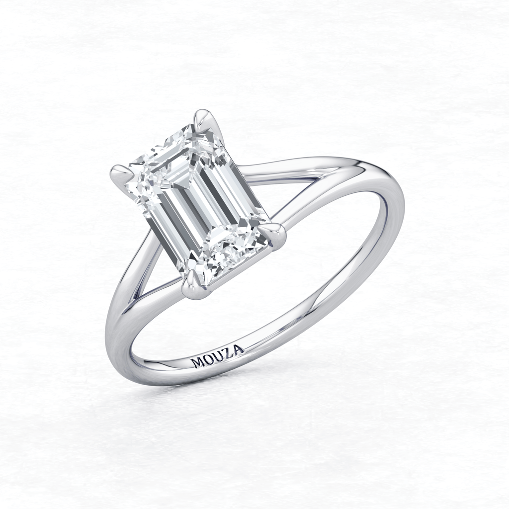 Elegant White Gold Maggy Solitaire Engagement Ring having a sleek design and brand name Mouza engraved on the metal band.